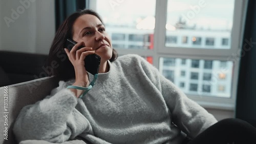 A Woman is Relaxing while Using a Smartphone in a Stylish and Modern Living Space