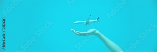 A male hand holds a small airplane model against a bright blue background, creating an interesting composition._00003_
