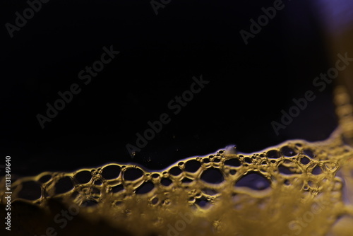 Bright bubbles at the bottom of the picture, minimalistic surface background, Yellow bubbles on black background, liquid abstraction photo