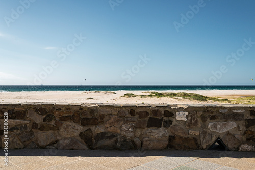 Stone wall and sandy beach overlooking ocean in Tarifa, Spain photo