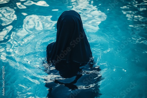 Arabian woman in burkini swims in the pool photo