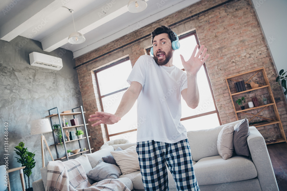 Fototapeta premium Photo of nice young man dancing headphones listen music wear pajama wake up enjoy modern cozy interior flat indoors