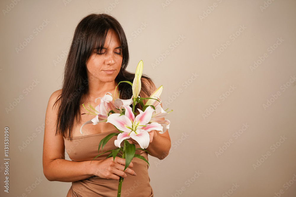 Cute young girl with long hair in a green dress, holding a bouquet of colorful flowers, enjoying the smell, smiling widely with closed eyes, standing on a white background. Cute young girl with long hair in a green dress, holding a bouquet of colorful flowers, enjoying the smell, smiling widely with closed eyes, standing on a white background.