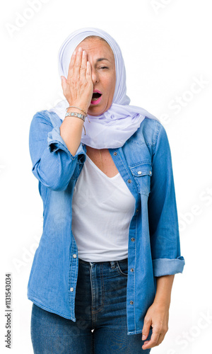 Middle age eastern arab woman wearing arabian hijab over isolated background Yawning tired covering half face, eye and mouth with hand. Face hurts in pain. photo