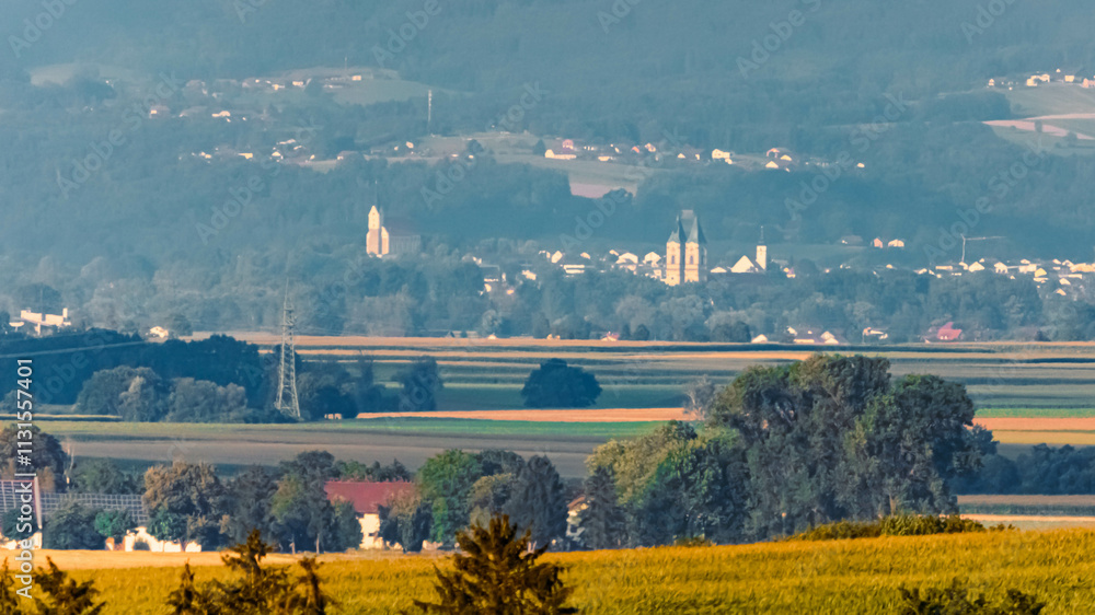 Fototapeta premium Far view of the churches of Hengersberg and Niederalteich seen from near Ettling, Wallersdorf, Dingolfing-Landau, Bavaria, Germany
