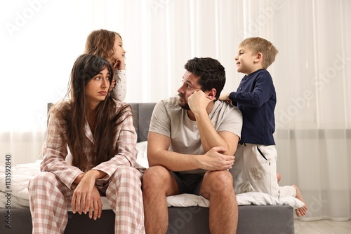Принти на полотні Playful children and their overwhelmed parents on bed at home