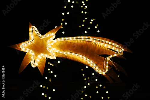 Ein leuchtender Weihnachtsstern vor den verschwommenen Lichtern eines Weihnachtsbaums photo