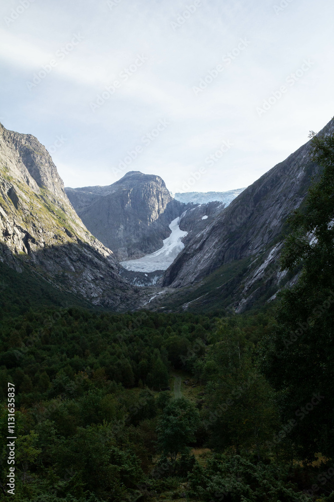 Fototapeta premium Jostedalsbreen Glacier stands majestically, with its vast icy expanse surrounded by towering, snow-capped mountains.