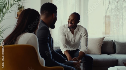 Friendly African American real estate agent interacting warmly with clients in a modern living room, showcasing professionalism, trust, and a welcoming atmosphere.