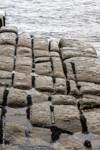 Waves splashing on the tessellated pavement on the edge of Pirates Bay, Tasmania photo