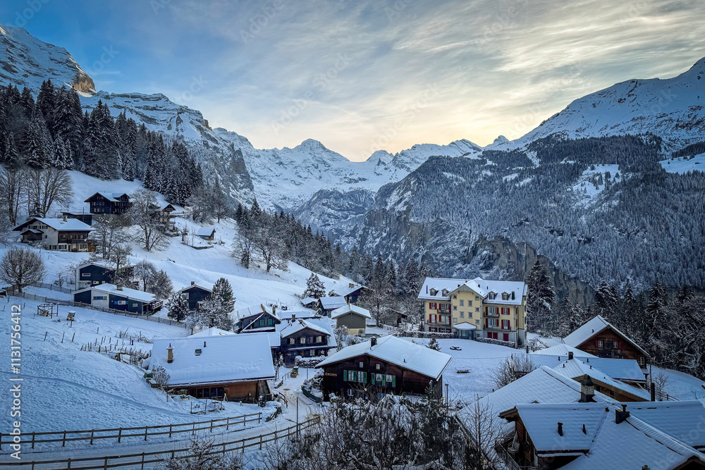 Scenic view of Wengen and Lauterbrunnen Valley, Switzerland with snowcovered mountains in winter against blue sky at sunset
