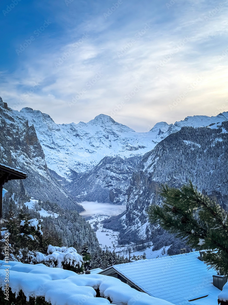 Scenic view of Lauterbrunnen Valley, Switzerland seen from Wengen with snowcovered Breithorn mountain in winter against blue sky with clouds