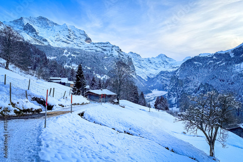 Scenic view of Lauterbrunnen Valley, Switzerland with snowcovered mountains Breithorn (middle) and Jungfrau (left) in winter against blue sky with clouds seen from Wengen