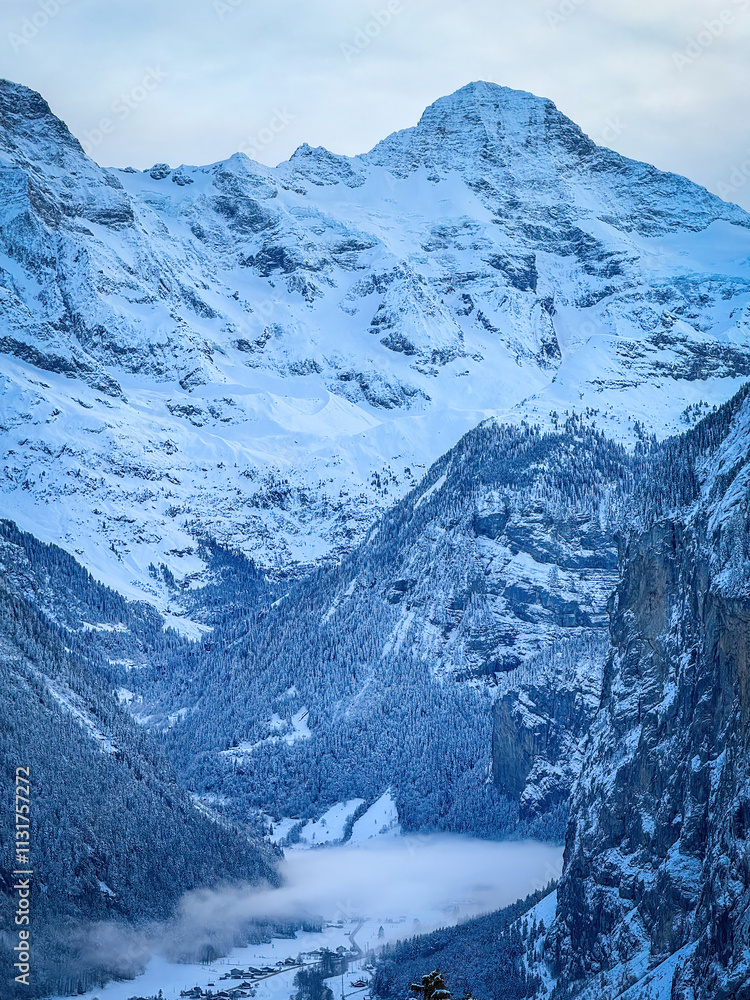 Scenic view of Lauterbrunnen Valley and Breithorn mountain, Switzerland seen from Wengen in winter against blue sky with clouds