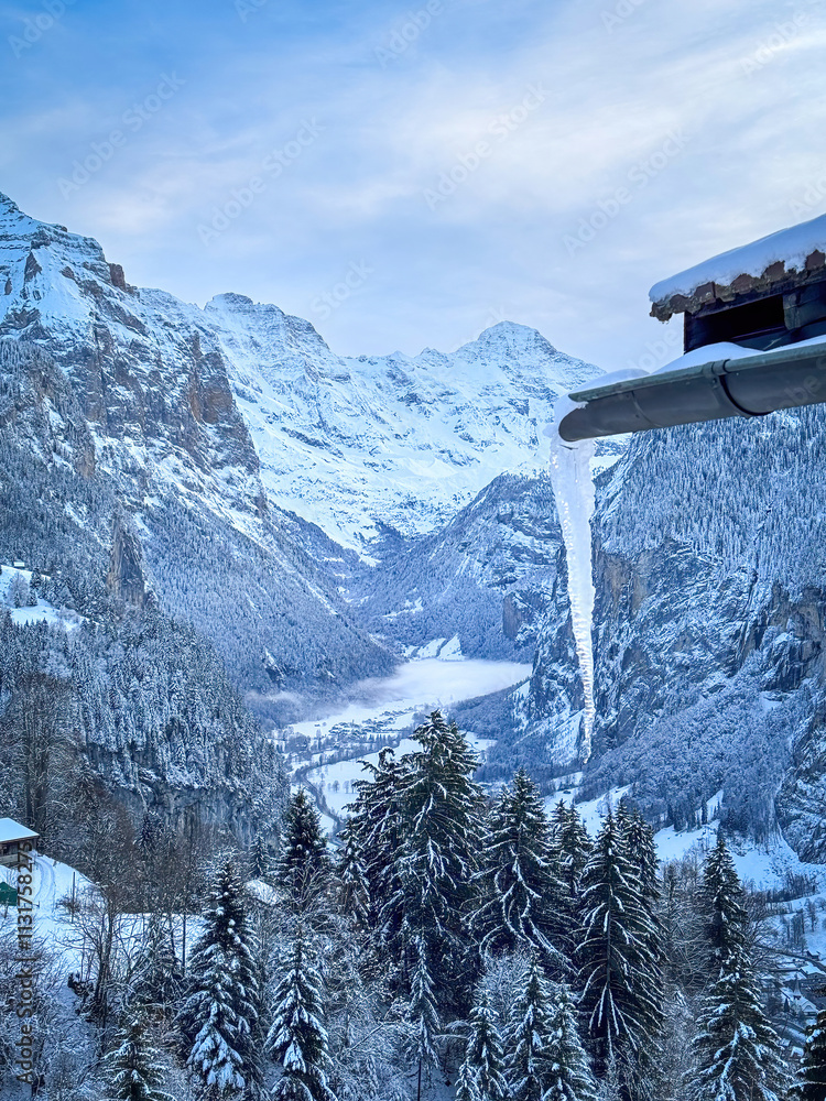Scenic view of Lauterbrunnen Valley, Switzerland seen from Wengen with snowcovered Breithorn mountain in winter against blue sky with clouds