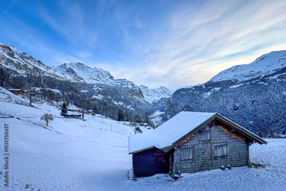 Panoramic view of Lauterbrunnen Valley, Switzerland seen from Wengen with snowcovered Breithorn (right) and Jungfrau (left) mountain in winter against blue sky with clouds