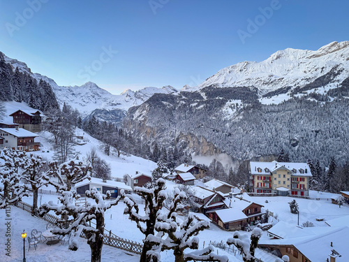 Obraz na płótnie Scenic view of Wengen and Lauterbrunnen Valley, Switzerland with snowcovered mountains in winter against blue sky at sunset w salonie