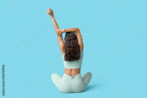 Sporty young woman stretchi...