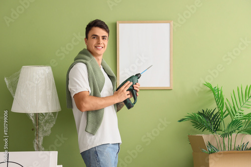 Young man with drill near h...