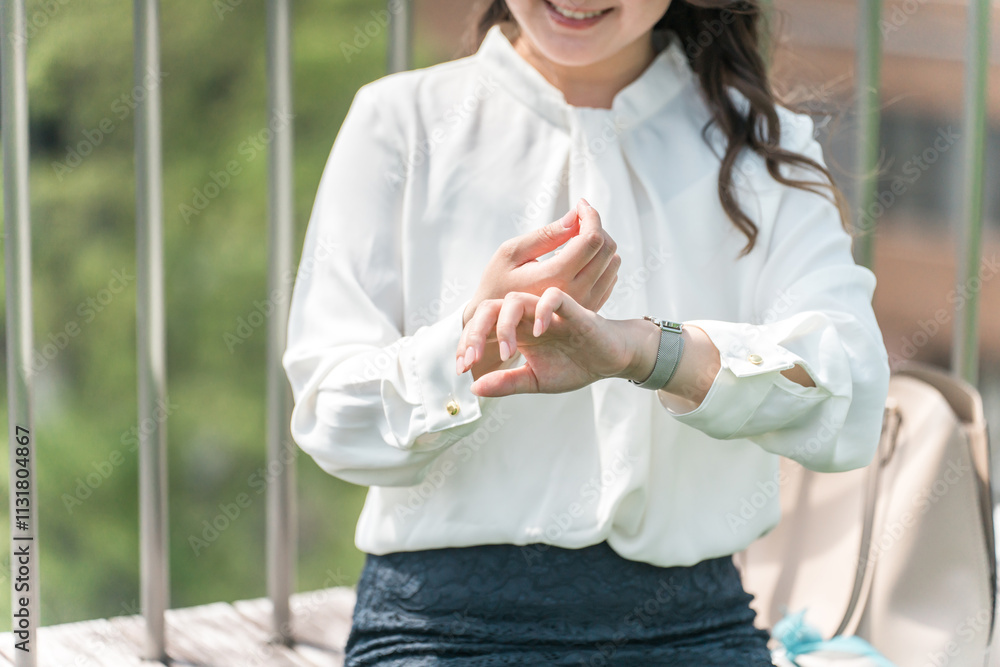 Naklejka premium 日焼け止め・制汗剤を塗る若いアジア人ビジネスウーマン（紫外線対策・デオドラント・スキンケア） 