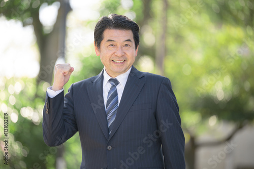 新緑の中事業承継や社長や経営者のカメラ目線イメージ　ガッツポーズ