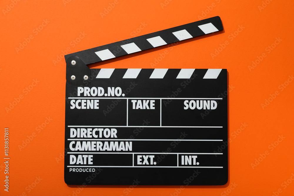 Naklejka premium Clapperboard for filming on orange background, top view