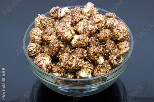 Glass Bowl Filled With Chocolate-Coated Popcorn on a Dark Background