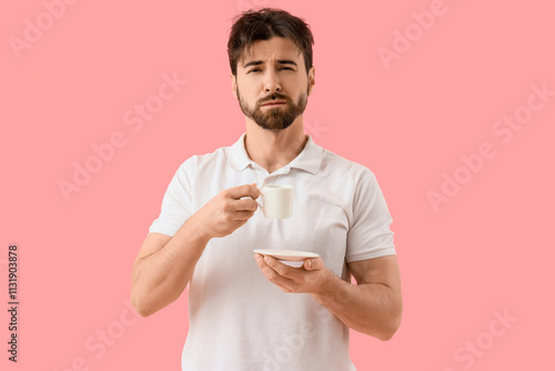 Sleepy young man with cup o...