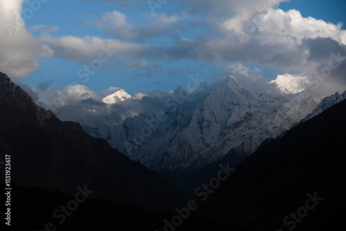 Morning sun shining over snow covered mountains peaks in the himalayas near Nabhi village in Uttarakhand, India photo