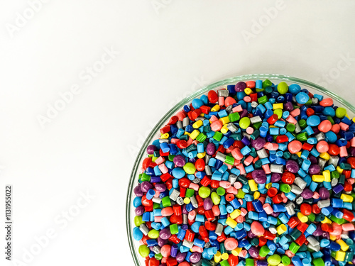 colorful masterbatch plastic granules, masterbatch plastic pigment granules in laboratory pantry cup isolated on white background, for product catalog design of industrial plastic manufacturing compan photo