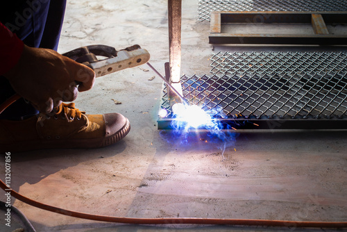 Welder is welding add joint at a construction site weld metal structures of  Steel frames and grids for use in construction.