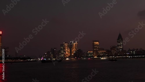 Night view Shanghai city with illuminated skyline, Oriental Pearl Tower and scyscrappers, reflecting on water of Huangpu river. Vibrant and modern cityscape in the evening. Travel destination. photo