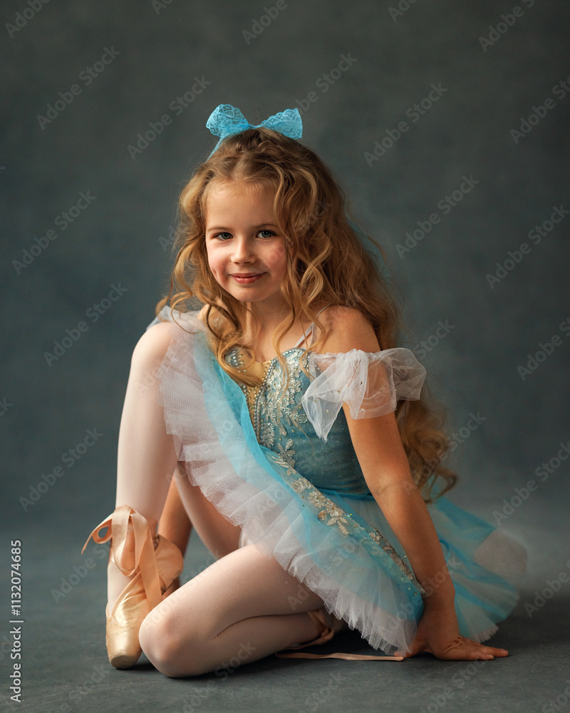 A ballerina girl in a ballet skirt and pointe shoes poses with Little adorable child ballerina in ballet tutu practicing classic choreography in ballet school, in studio