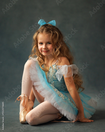 Obraz na płótnie A ballerina girl in a ballet skirt and pointe shoes poses with Little adorable child ballerina in ballet tutu practicing classic choreography in ballet school, in studio w salonie
