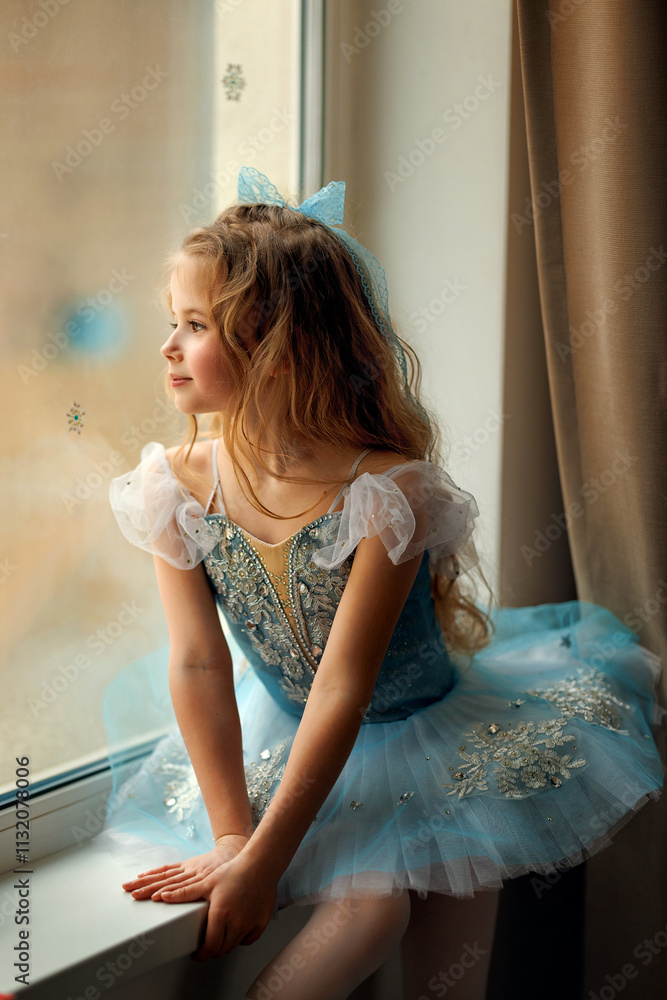 A ballerina girl in a ballet skirt and pointe shoes poses with Little adorable child ballerina in ballet tutu practicing classic choreography in ballet school, in studio