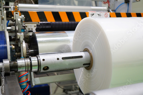 Plastic film roll on winding unit of Blown film plastic bag-making machine.