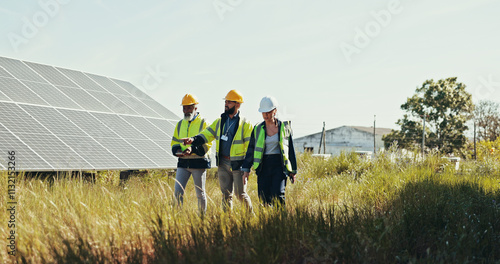 People, technician and walking with team for solar panel installation, photovoltaic development or eco project in nature. Group, engineer or contractors with helmet for renewable energy or power photo