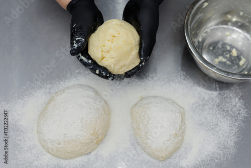 Cooking Ossetian pie with yellow filling - cottage cheese, cheese on the kitchen table in restaurant photo