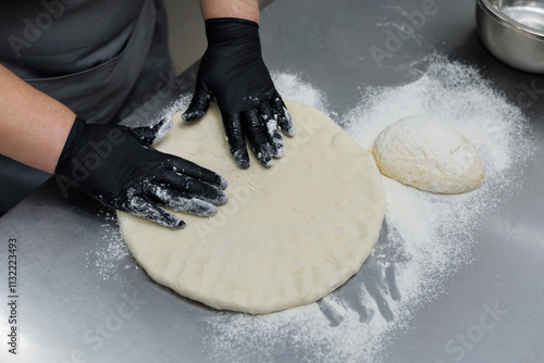 Cooking Ossetian pie with yellow filling - cottage cheese, cheese on the kitchen table in restaurant photo