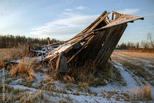 Old collapsed barn in December winter sunlight photo