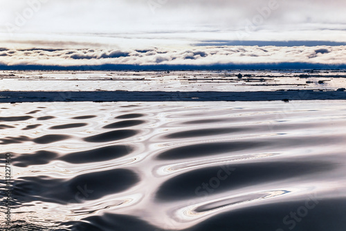 Wave pattern in the ocean with a cloud bank photo