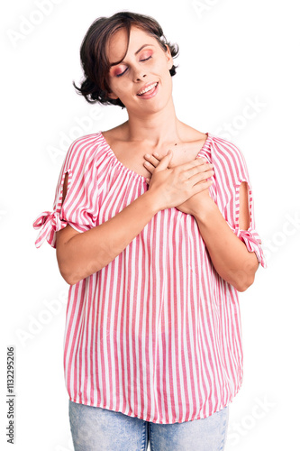 Beautiful young woman with short hair wearing casual summer clothes smiling with hands on chest with closed eyes and grateful gesture on face. health concept.