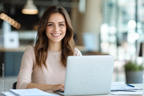 Smiling woman working at a laptop in a modern office setting. Bright, professional, and motivating workspace showcasing productivity and focus in an urban environment. Free Download Smiling woman working at a laptop in a modern office setting. Bright, professional, and motivating workspace showcasing productivity and focus in an urban environment. - GFXLoad