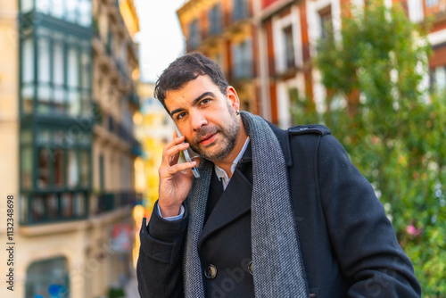 Casual businessman talking to the mobile phone in the city photo