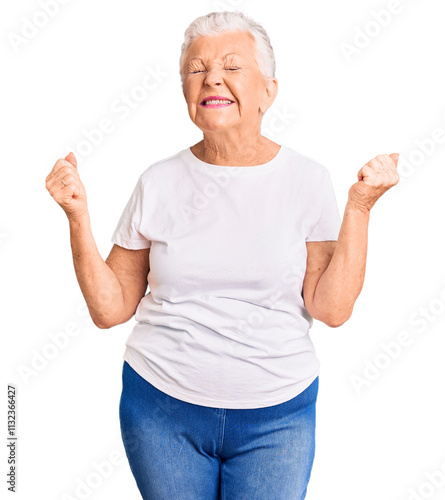 Senior beautiful woman with blue eyes and grey hair wearing casual white tshirt very happy and excited doing winner gesture with arms raised, smiling and screaming for success. celebration concept.