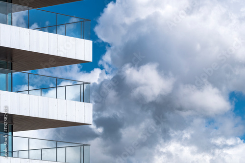 A striking minimalist architectural design with clean lines, distinguished by wide balconies and framed against a dramatic sky, exuding modern sophistication and simplicity. photo