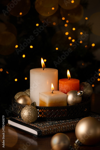 Festive winter decoration with three candles and glitter Christmas balls on the table
