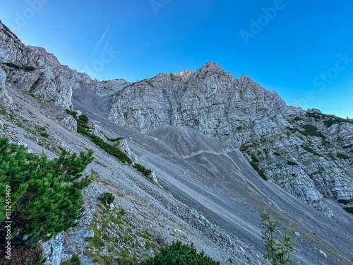 Dramatic mountain landscape along hiking trail to Begunjscica with rugged cliffs and rocky formations. Wanderlust Loibl Pass in Karawanks, Slovenia Austria. Tranquil atmosphere in alpine wilderness photo