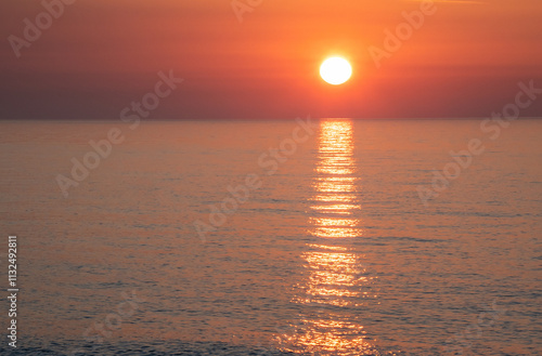 Sunrise over sea with reflections on calm water