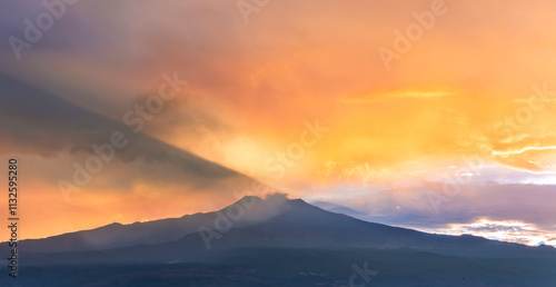 beautiful panorama of volcano mountain during evening synset with twilight clouds and shadows above majectic mountain and amazing cloudy sunset sky on background photo